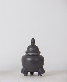 Black glazed three legged animal face jar