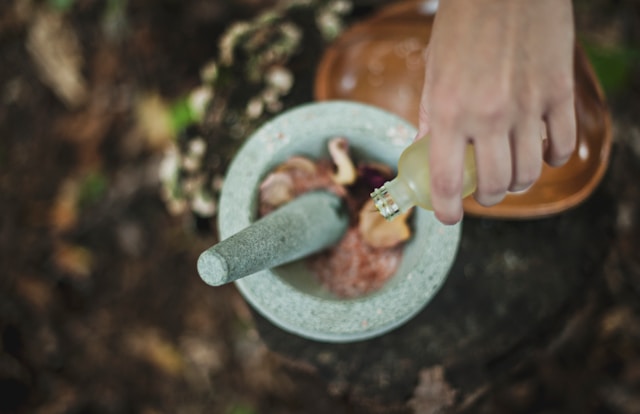 A person using a mortar and pestle to grind ingredients in a bowl of food.jpg