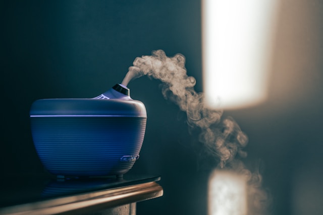 A blue and black diffuser releasing smoke, creating a soothing atmosphere.jpg