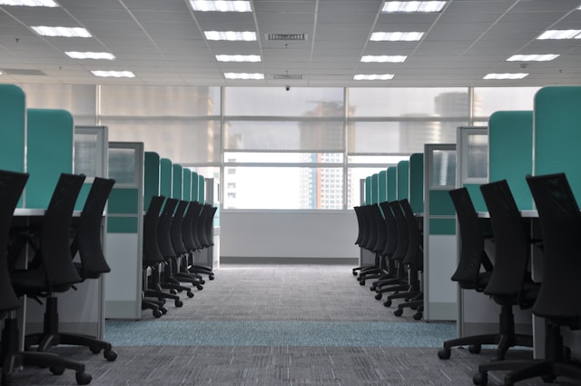 Rows of chairs and desks in an office with carpeted floors..jpg